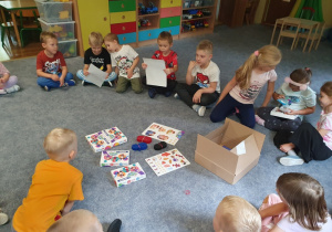 Dzieci oglądają pakiet materiałów do zajęć edukacyjnych o zdrowiu.