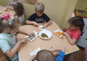 Dzieci kroją warzywa na sałatkę.