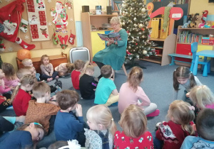 Dzieci słuchają czytanej bajki o Tuptusiu.