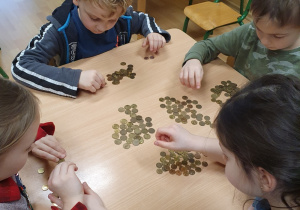 Dzieci segregują monety.