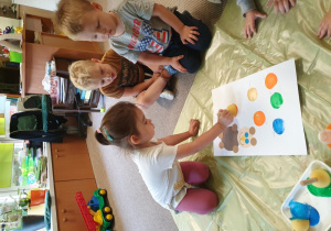 Dzieci stemplują baloniki farbą tworząc urodzinowa kartkę.