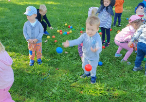 Zabawy z kolorowymi piłkami w ogrodzie przedszkolnym.