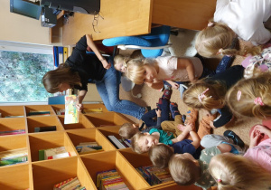 Dzieci słuchają opowiadania czytanego przez nauczycielkę.