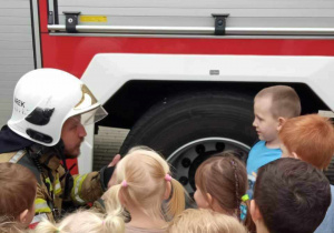 Strażak udziela dzieciom instrukcji postepowania w przypadku pożaru.