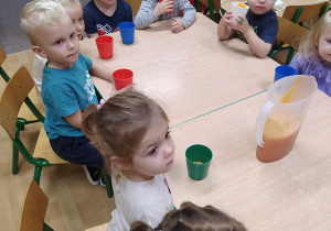 Dzieci piją przygotowany sok.