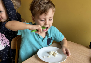 dzieci jedzą przyrządzony twarożek