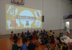 Dzieci oglądają prezentację dotyczącą pluszowych misiów.