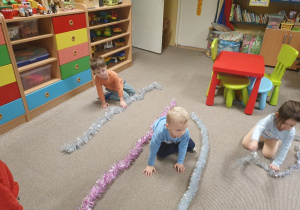 Dzieci porównują długość łańcuchów choinkowych.