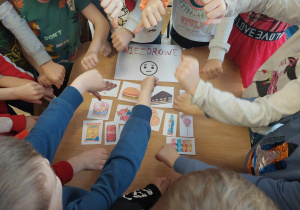 Dzieci wybierają karty z produktami spożywczymi.