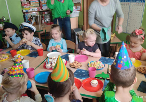 Dzieci konsumują słodkie urodzinowe babeczki.