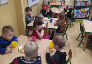 Dzieci jedzą przyniesione przez rodziców przekąski.