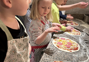 dzieci przygotowują pizzę