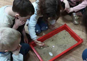 dzieci poszukują skarbów w piasku