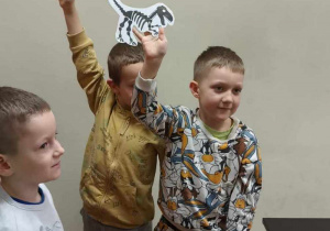chłopcy pokazują szkielet dinozaura