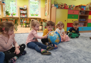 Dzieci oglądają globus.