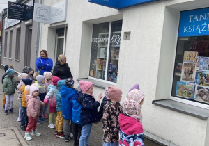 Dzieci stoją przed księgarnią