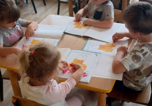 dzieci pracują w książkach przy stoliku