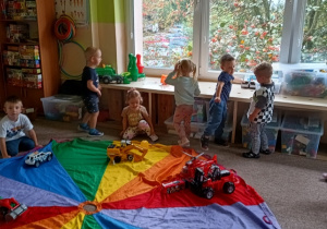 przedszkolaki układaja na chuście przedmioty zgodnie z kolorem