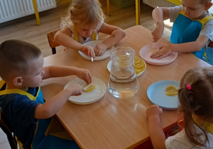 przedszkolaki kroją plasterki cytryny