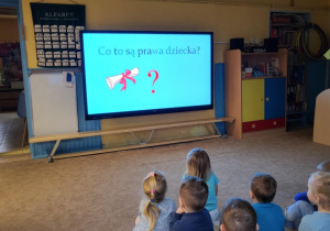 Dzieci oglądają film edukacyjny o prawach dziecka.