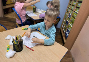 Chłopiec wykonuje pracę plastyczną