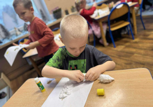 Chłopiec wykonuje pracę plastyczną