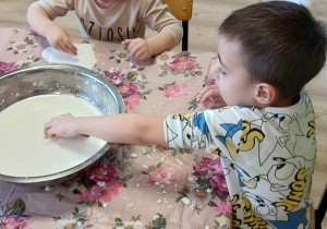 dzieci lepią z białej masy sensorycznej