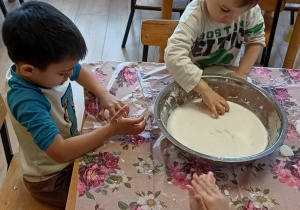 dzieci lepią z białej masy sensorycznej