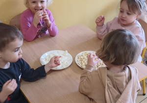 dzieci zajadają białe przekąski
