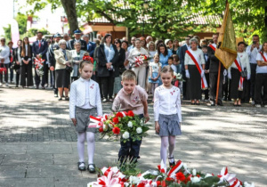 Dzieci składają kwiaty pod pomnik