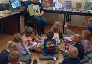 Pani Bibliotekarka prezentuje dzieciom ilustracje z książki