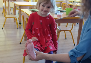 dziewczynka ma pomalowaną stopę na kolor różowy