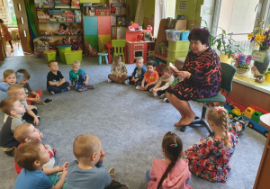 Babcia dziewczynki czyta przedszkolakom.