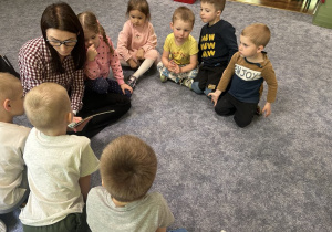 Mama dziewczynki czyta przedszkolakom.