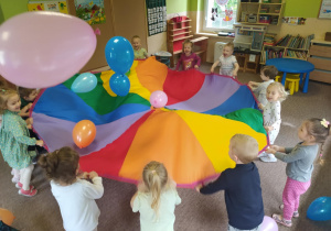 dzieci podrzucają balony na chuście