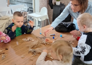 dzieci wyklejają figurkę wełną