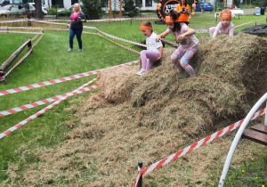 Dzieci pokonują stóg siana.