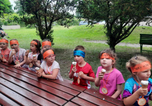 Dzieci jedzą lody.