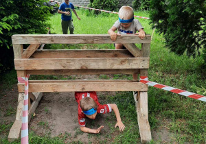 Dzieci przechodzą pod paletą.