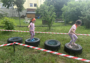 Dzieci przeskakują przez opony.