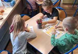 Segregowanie śmieci- dzieci rozwiązują zadania w kartach pracy.