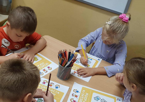 Segregowanie śmieci- dzieci rozwiązują zadania w kartach pracy.