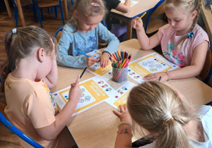 Dzieci rozwiązują zadania w kartach pracy.