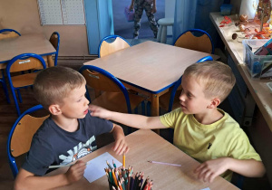 dzieci rysują przy stolikach
