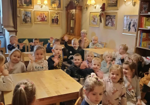 dzieci siedzą przy stolikach w kawiarence