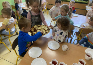 Dzieci częstują się chałką.
