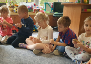 Dzieci oglądają pierścionki i kamienie szlachetne.