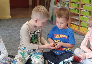 Dzieci oglądają sztabkę złota.