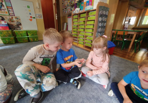 Dzieci oglądają sztabkę złota.