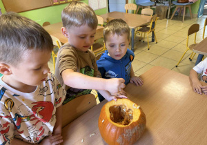 Dzieci badają zawartość dyni.